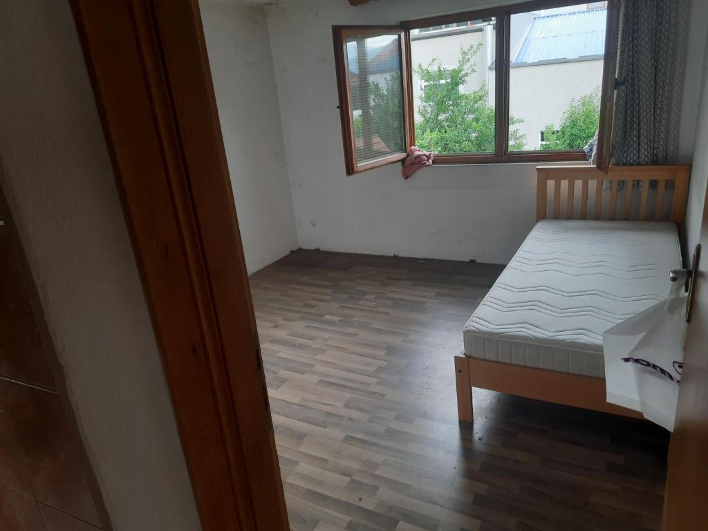a small room with a bed and a window at Hanka Delic Lepinac in Gračanica