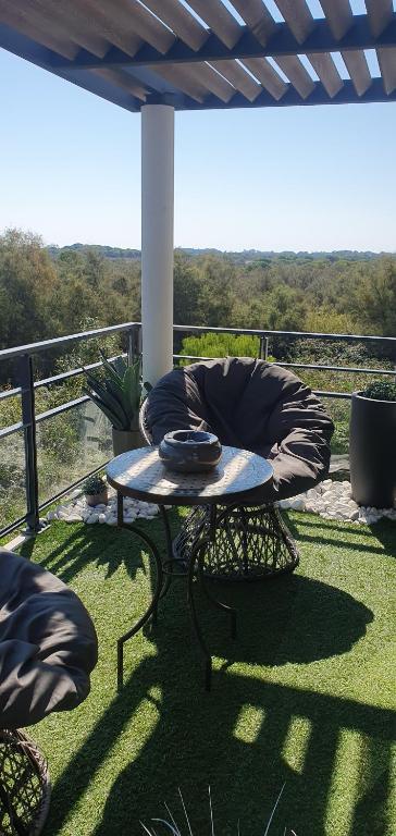 a patio with a table and a chair on a balcony at Appartement de L'Espiguette in Le Grau-du-Roi