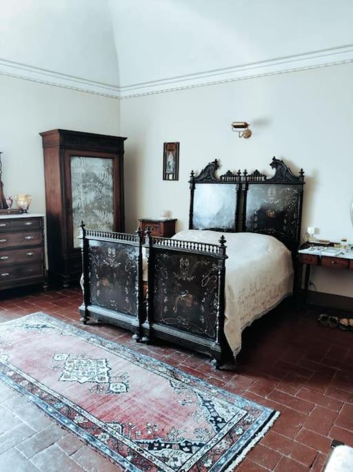 a bedroom with a large bed and a rug at Nel borgo con vista castello in Poppi