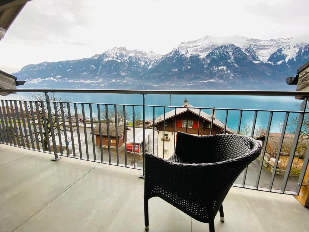 a chair on a balcony with a view of the mountains at LakeSide Villa - 18 in Niederried
