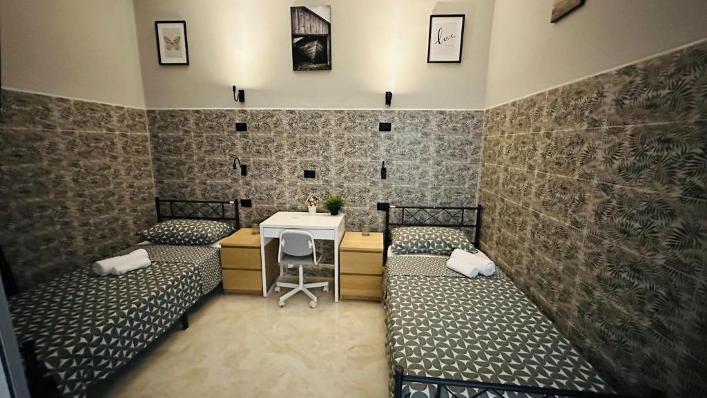 Zimmer mit 3 Betten, einem Schreibtisch und einem Tisch in der Unterkunft Soha's Holiday in Rom