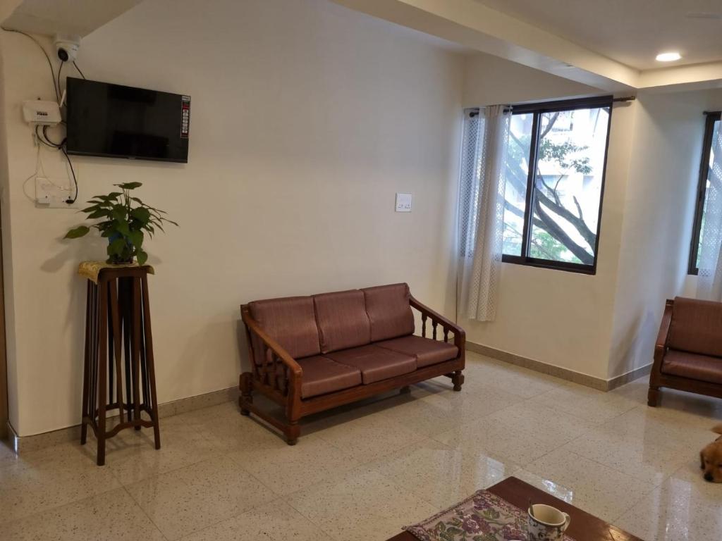 a living room with a couch and a flat screen tv at Cinnamon House in Pune