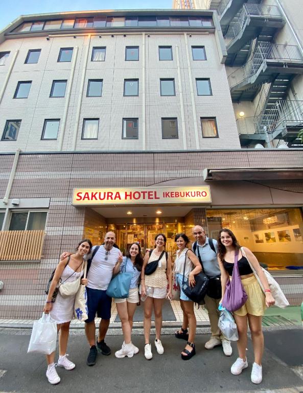 a group of people standing in front of a hotel at Sakura Hotel Ikebukuro in Tokyo