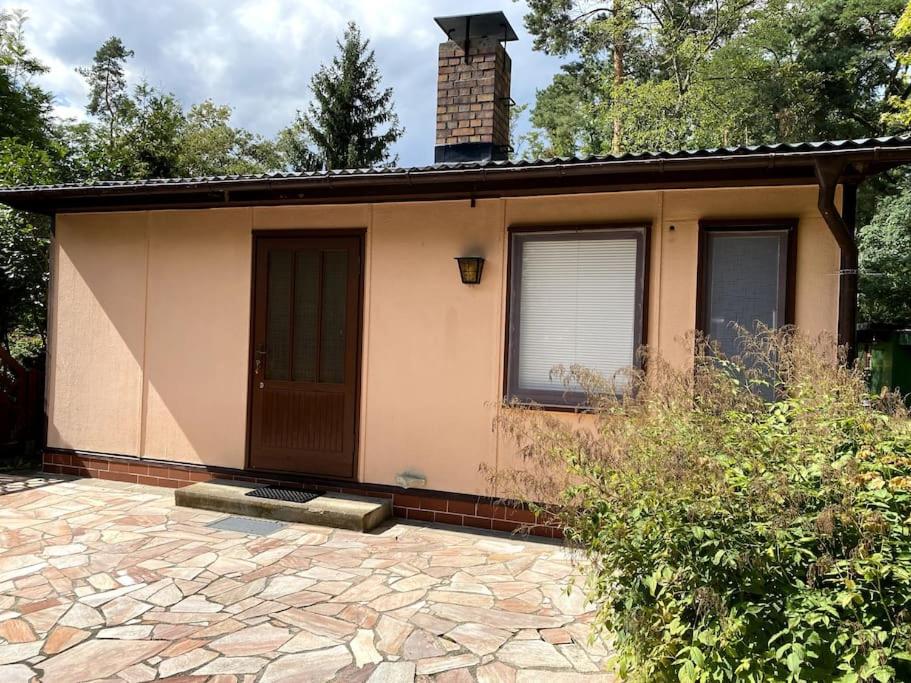 a small house with a brick patio in front of it at Gästehaus Zur Walnuss Berlin in Blankenfelde