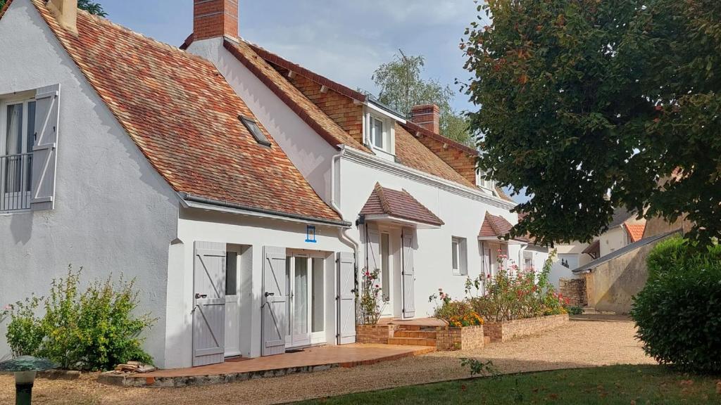 une maison blanche avec un toit rouge dans l'établissement Cottage de 13 personnes proche du Mans, à Le Breil-sur-Mérize