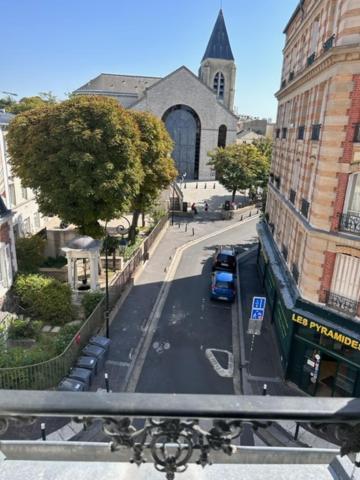 uma vista para uma rua da cidade com uma igreja em Appartements sympas et confortables em Nanterre