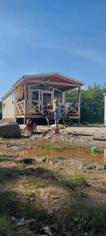 a girl is standing in front of a house at Strandhuisje in Voorthuizen