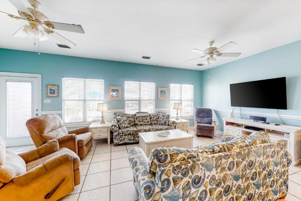 a living room with couches and a flat screen tv at Purple House East and West in Fort Morgan