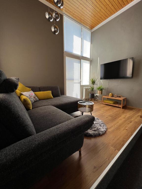 uma sala de estar com um sofá e uma televisão de ecrã plano em fichtel.flat em Mehlmeisel