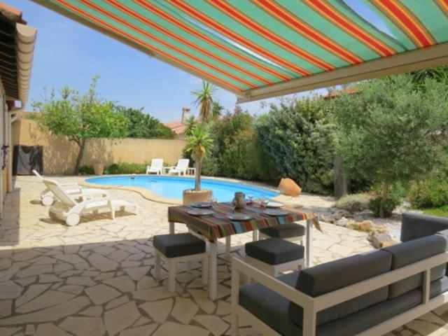 une terrasse avec une table, des chaises et une piscine dans l'établissement Villa familiale piscine privée 6 personnes 6BJ21, à Saint-Estève
