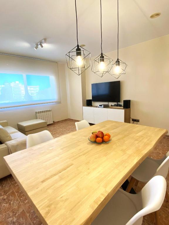 a dining room with a wooden table with fruit on it at Atico duplex en Malgrat de Mar in Malgrat de Mar