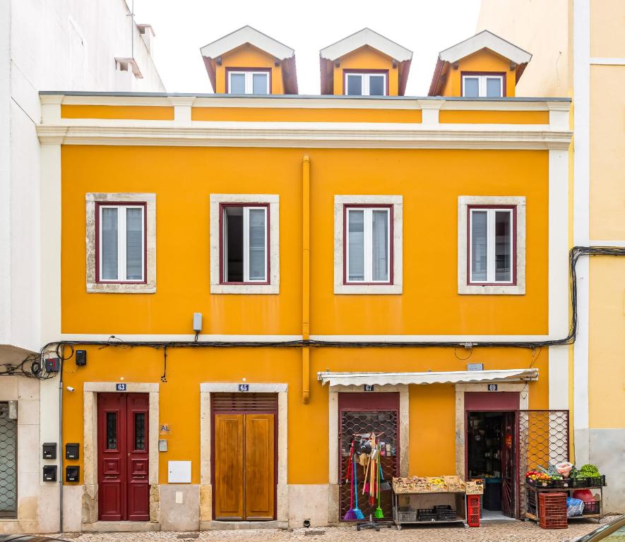 un edificio naranja con ventanas y puertas en Golden Place - Cacilhas, en Almada