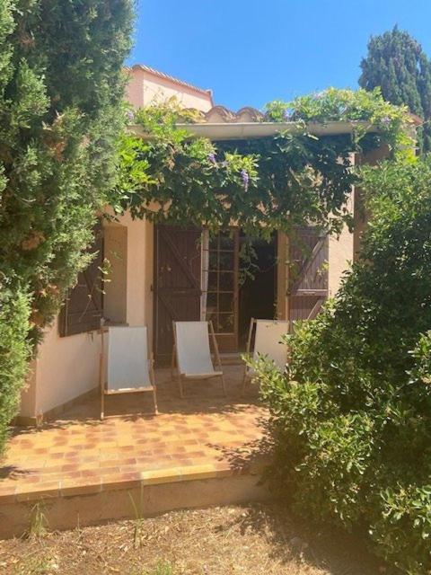 une maison avec 2 chaises blanches sur une terrasse dans l'établissement Maison familiale à 2 minutes minutes des plage 6DID1, au Barcarès