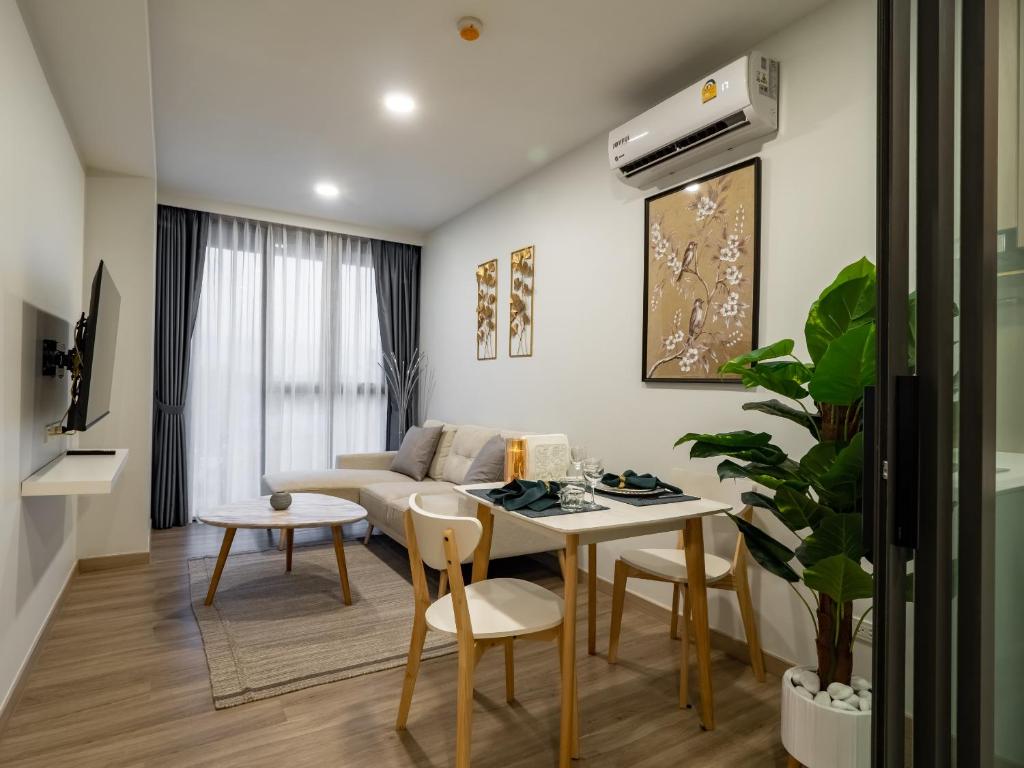 un soggiorno con tavolo e divano di Comfortable apartments in Laguna Skypark a Phuket