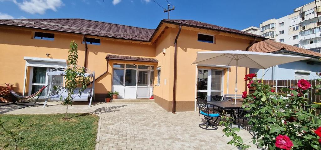 Casa Anton Buzău في بوزاو: منزل به طاولة ومظلة