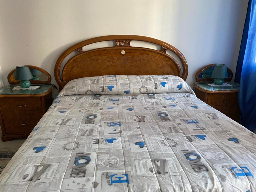 1 cama en un dormitorio con 2 mesitas de noche y 2 lámparas en Come a Casa!, en Oristano