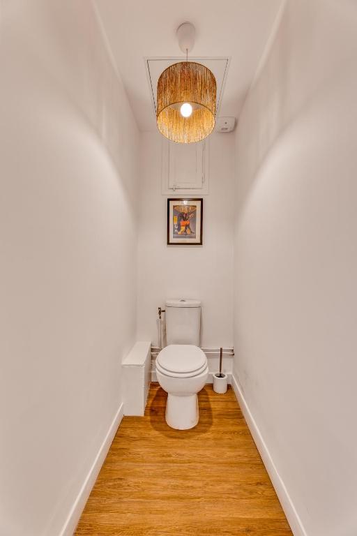 a bathroom with a toilet and a chandelier at ZenBNB - Évasion - Colocation - Ch 39 - Proche Transport in Annemasse