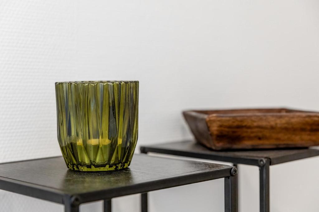 a green glass vase sitting on top of a table at ZenBNB - Évasion - Colocation - Ch 39 - Proche Transport in Annemasse