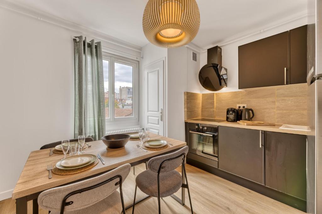 a kitchen with a wooden table with two chairs and a dining room at ZenBNB - Évasion - Colocation - Ch 39 - Proche Transport in Annemasse
