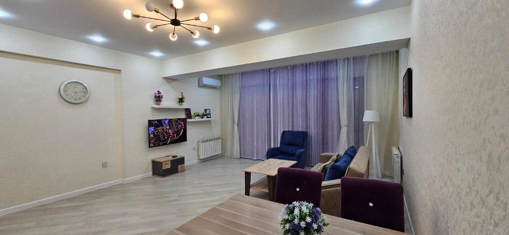 Park Azure Comfortable Apartment في باكو: غرفة معيشة مع طاولة وغرفة طعام