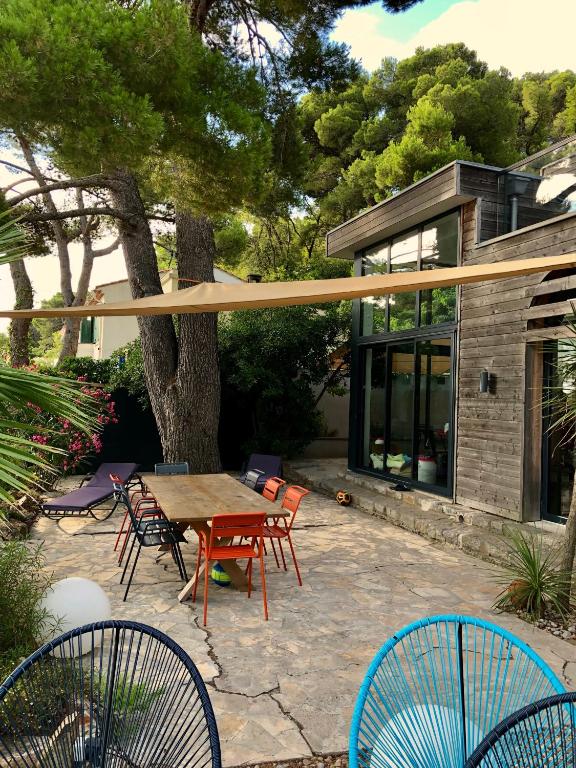 un patio avec une table et des chaises en bois dans l'établissement La Franqui Vue Mer Exceptionnel, à La Franqui-Plage