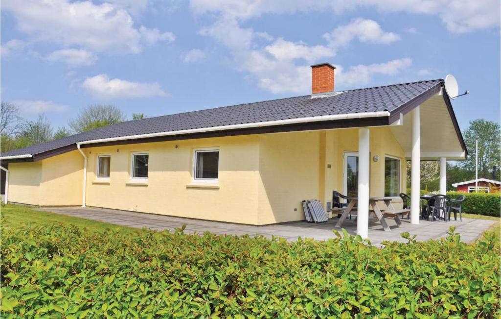 a yellow house with a patio in a yard at Cozy Home In Egernsund With Kitchen in Egernsund