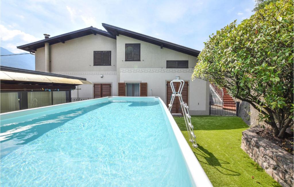 a swimming pool in front of a house at Nice Apartment In Rogno With Outdoor Swimming Pool, Wifi And 1 Bedrooms in Rogno