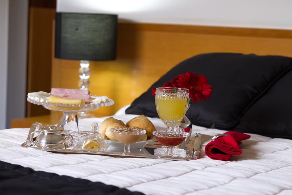 ein Tablett mit Speisen und Getränken auf dem Bett in der Unterkunft Hotel Canada in Ribeirão Preto