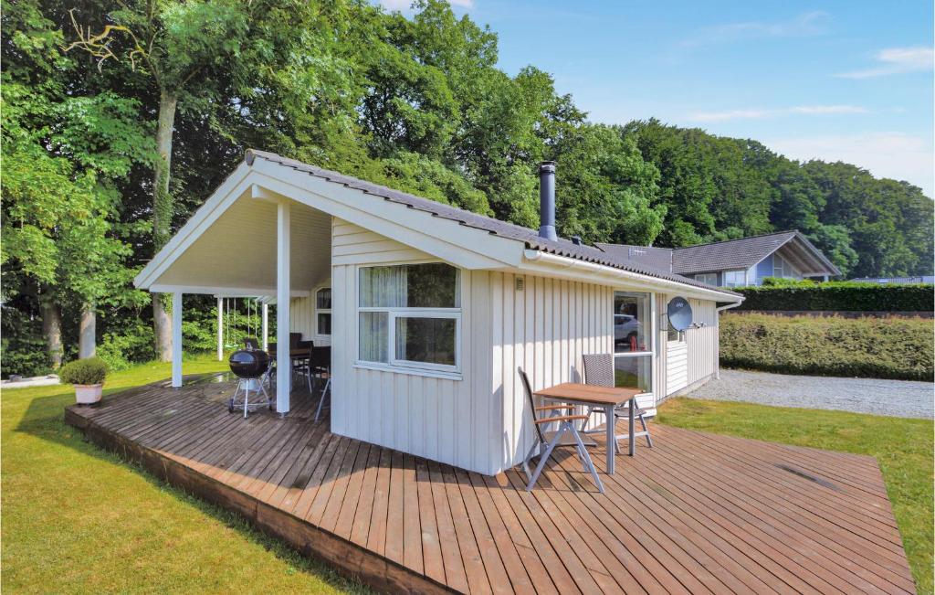a small white cabin with a table and chairs on a deck at 3 Bedroom Amazing Home In Aabenraa in Loddenhøj