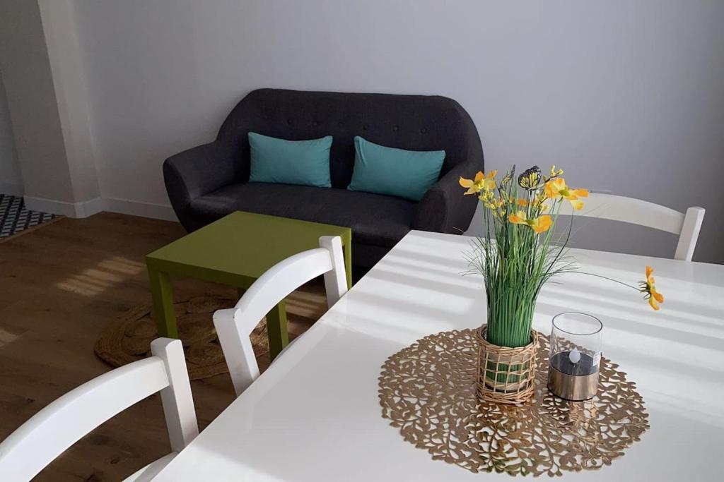 une table blanche avec un vase de fleurs sur elle dans l'établissement Super cozy appartement, à Marquette-lès-Lille