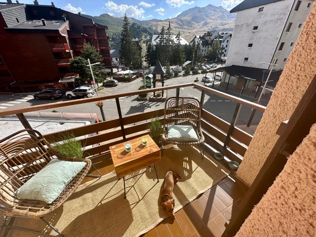 Un balcón con sillas, una mesa y una calle. en APARTAMENTO súper céntrico, con vistas a pistas y Wifi en Formigal