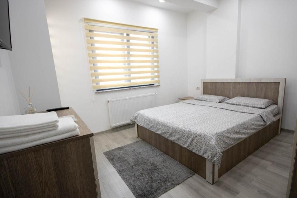 AStar Apartments - LARGE في راداوت: غرفة نوم بيضاء بها سرير ونافذة