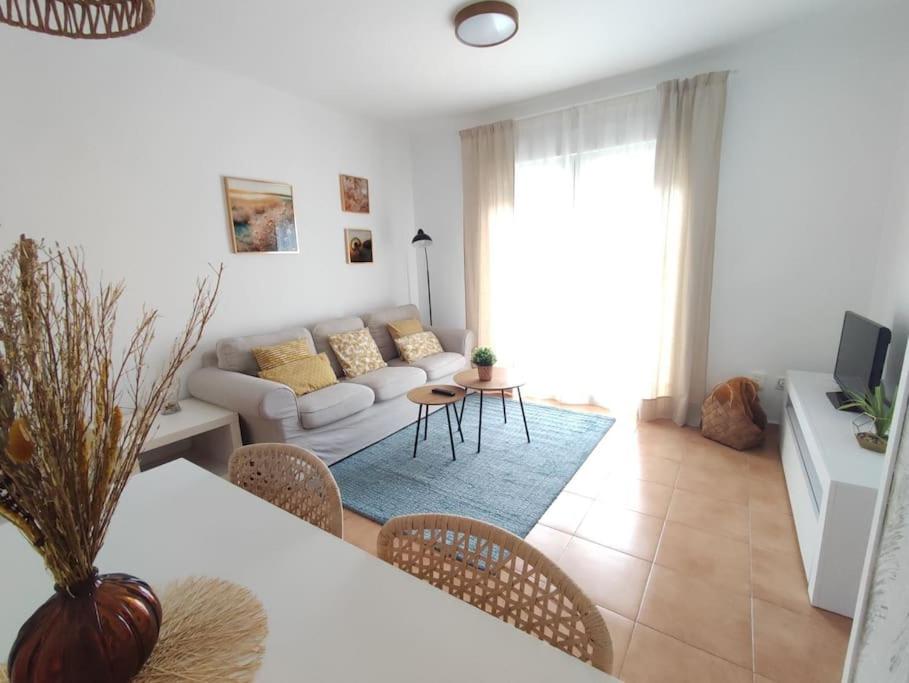 a living room with a couch and a table and chairs at Apartamento Puerto Chico in El Puerto de Santa María