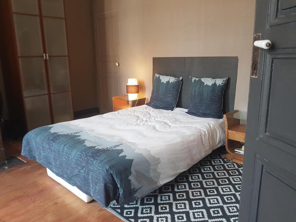 a bedroom with a large bed with blue pillows at Artbnb in Lézat-sur-Lèze
