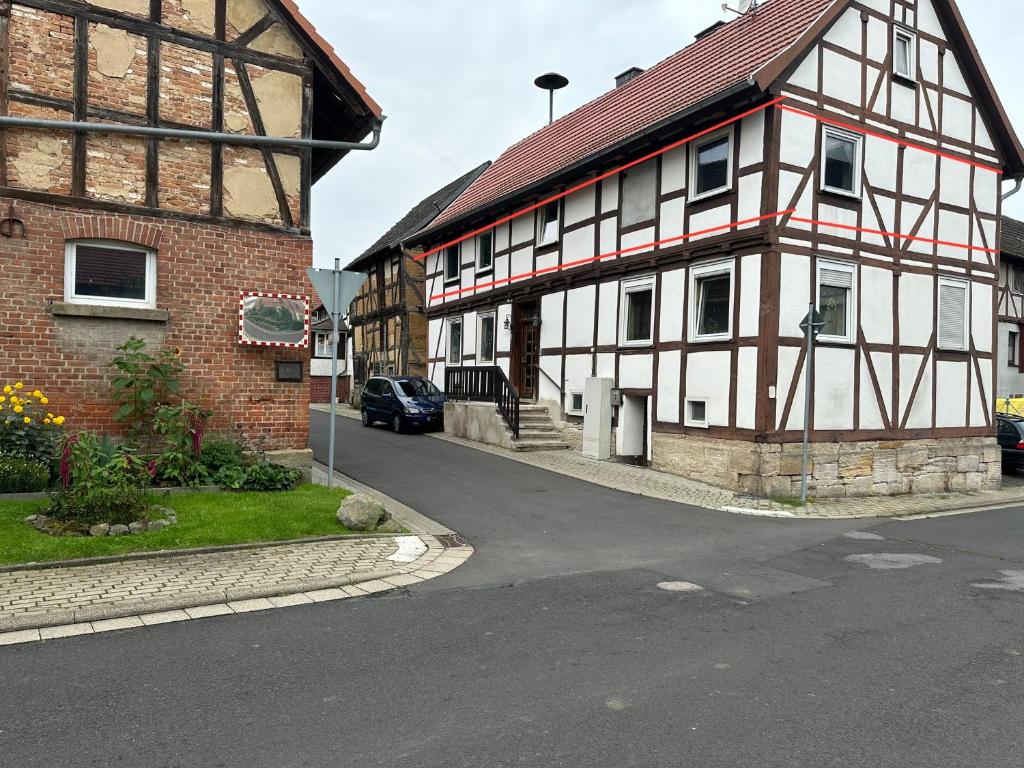 a building with a car parked next to a street at Diah's Apartment in BEUERN - für Monteure in Felsberg