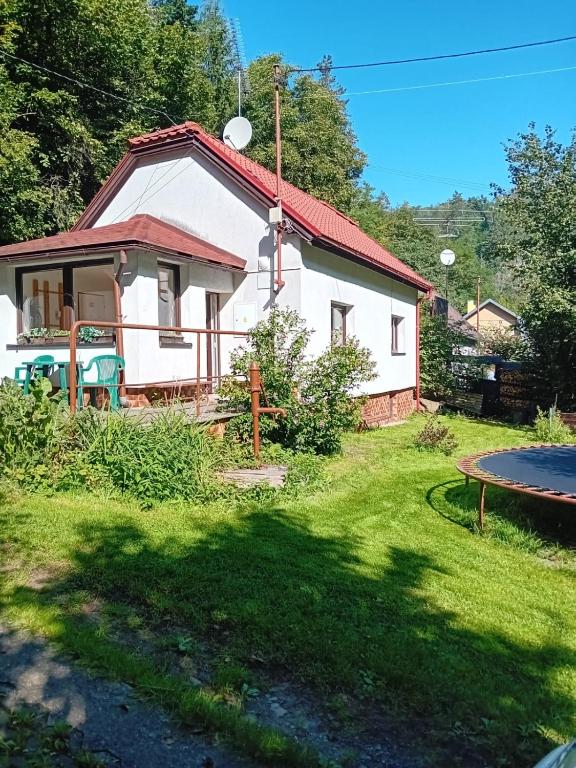 Casa blanca con cama elástica en el patio en Rekreační chata Kocába, en Štěchovice
