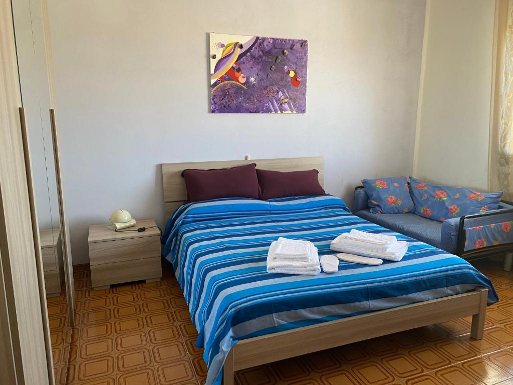 um quarto com uma cama e um sofá em Appartamento Scarlett em Villafontana