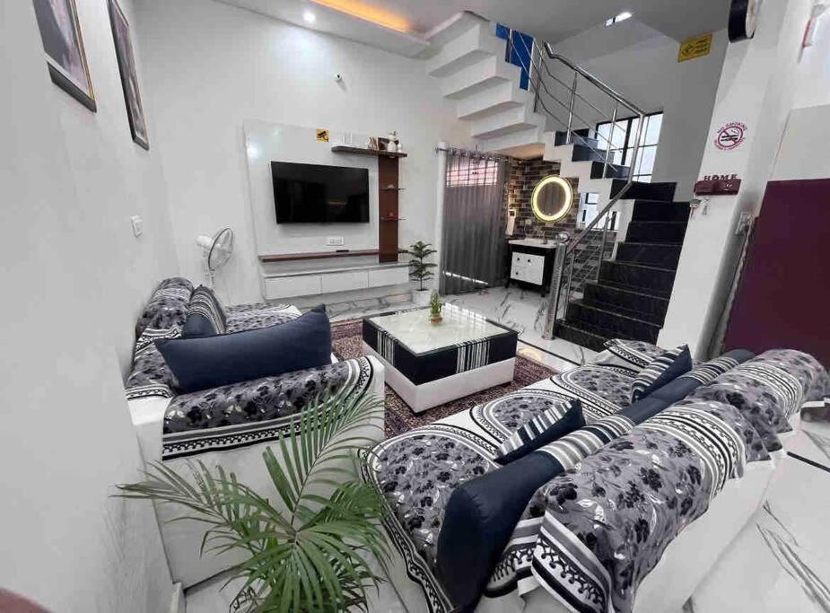 sala de estar con sofás y TV en The Bennett, en Amritsar