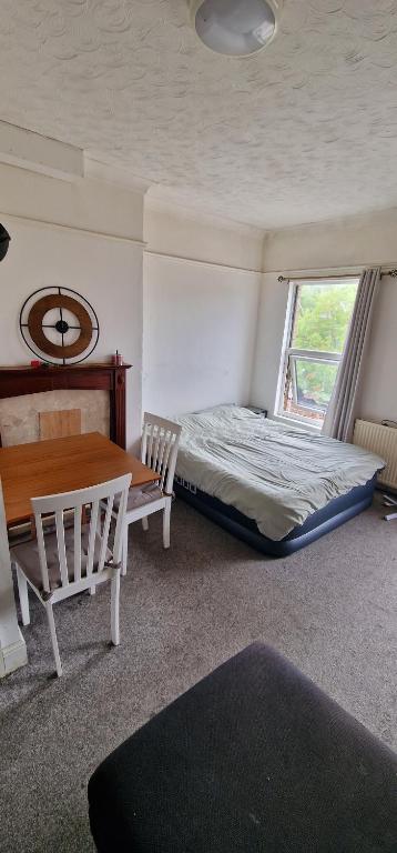 a bedroom with a bed and a table and chairs at 1 bed entire Studio Flat 10 min from City centre in Liverpool
