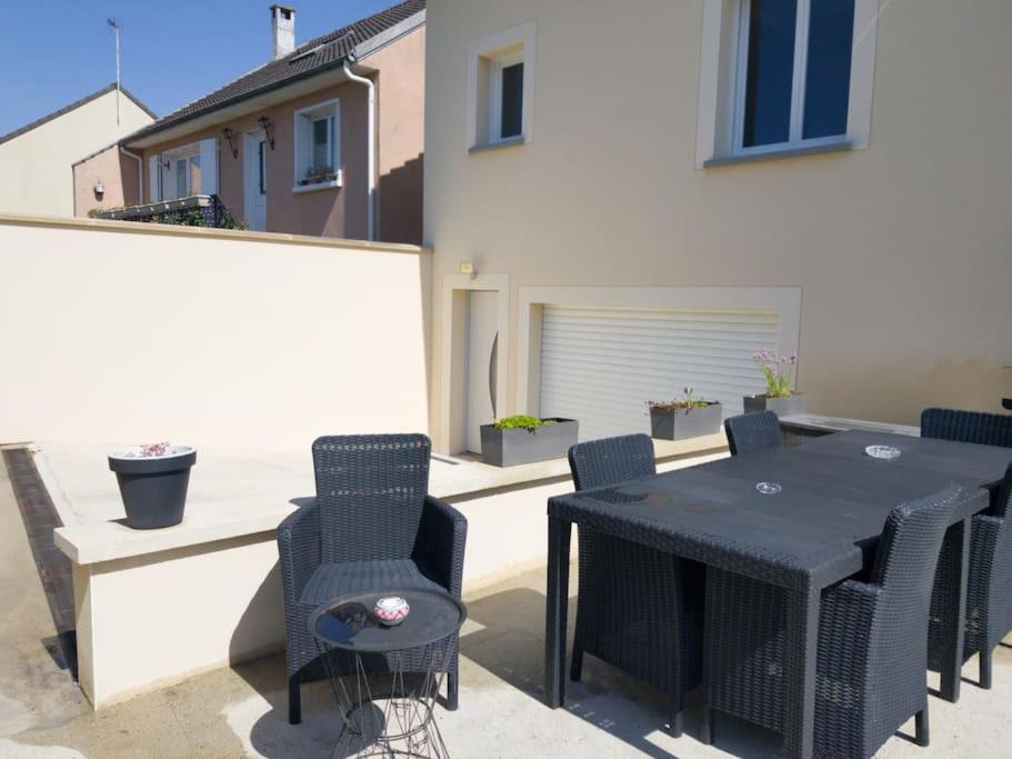 a black table and chairs sitting on a patio at Maison avec terrasse à 15 minutes de Disney in Nanteuil-lès-Meaux