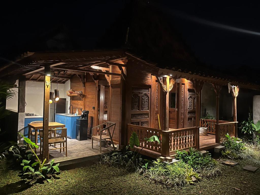a small house with a deck at night at Kaiwatu House in Ubud