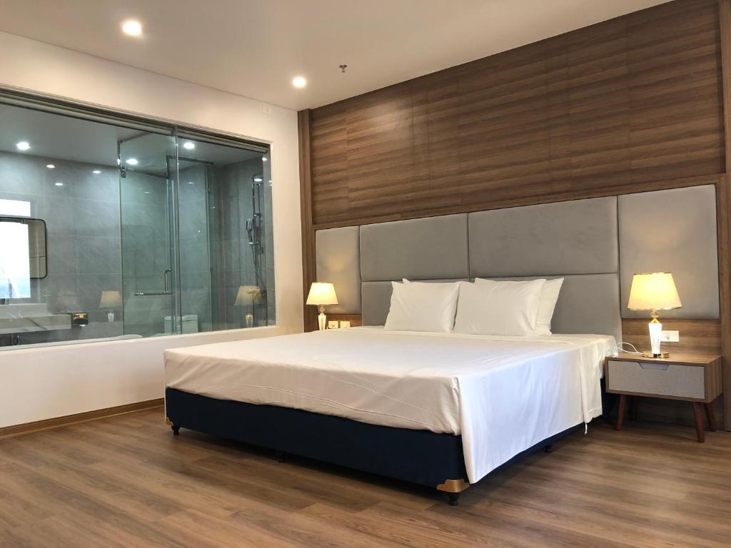 Central Halong Hotel في ها لونغ: غرفة نوم بسرير كبير ونافذة كبيرة