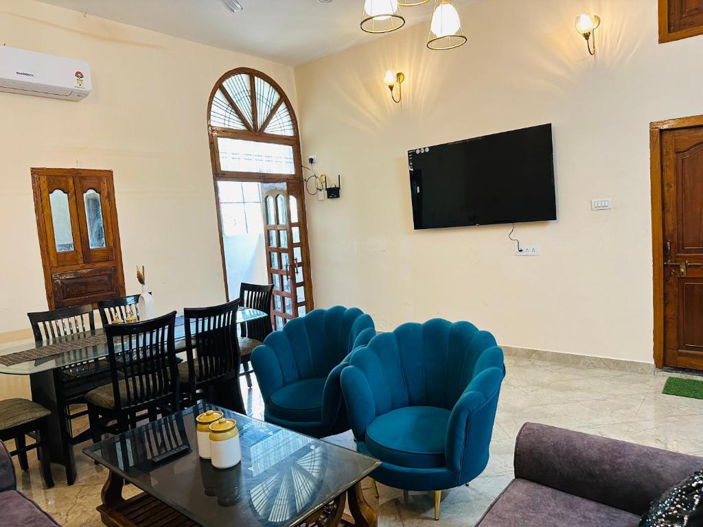 a living room with blue chairs and a tv at Bluetique in Varanasi