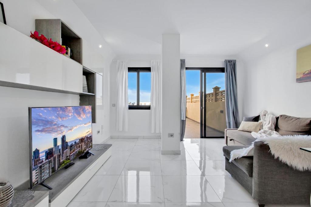 プラヤ・パライソにあるParadise Luxury Apartmentの白いリビングルーム(テレビ、ソファ付)