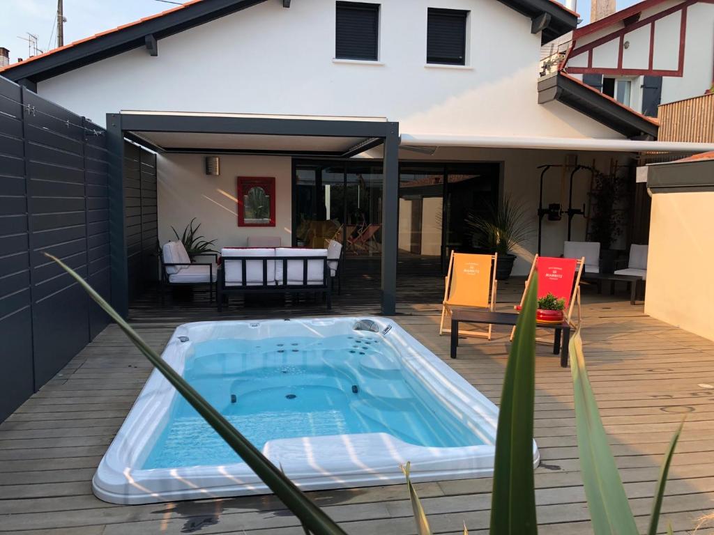 une piscine sur une terrasse à côté d'une maison dans l'établissement Villa à Biarritz avec une terrasse un SPA et parking, à Biarritz