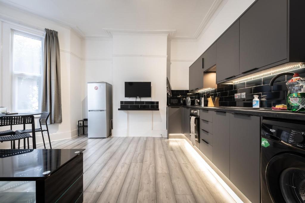a kitchen with black and white appliances at Newly Renovated 2 Bed Ground Floor Flat in Southampton