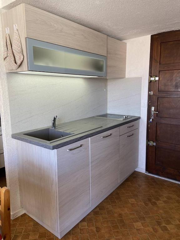 - une cuisine avec un évier et une porte en bois dans l'établissement Appartement 6 personnes - proche de la plage - Parking - 6FM34B1, au Barcarès