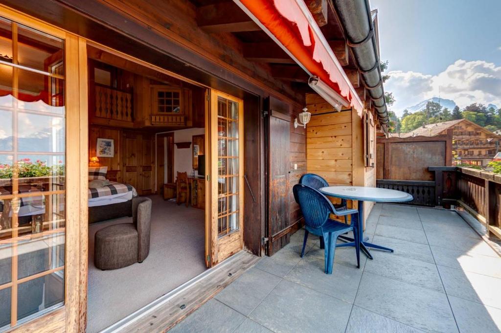a room with a table and chairs on a balcony at Alpe Fleurie Hôtel & Restaurant in Villars-sur-Ollon