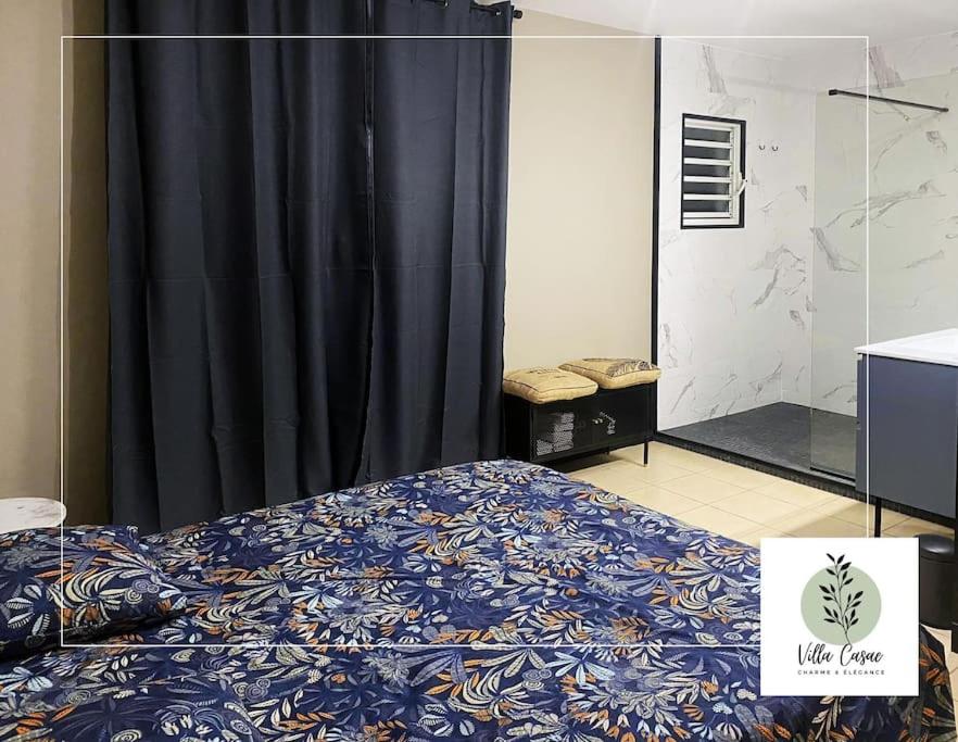 een slaapkamer met een bed en een zwart gordijn bij Villa Casae à Moulin joli in La Possession