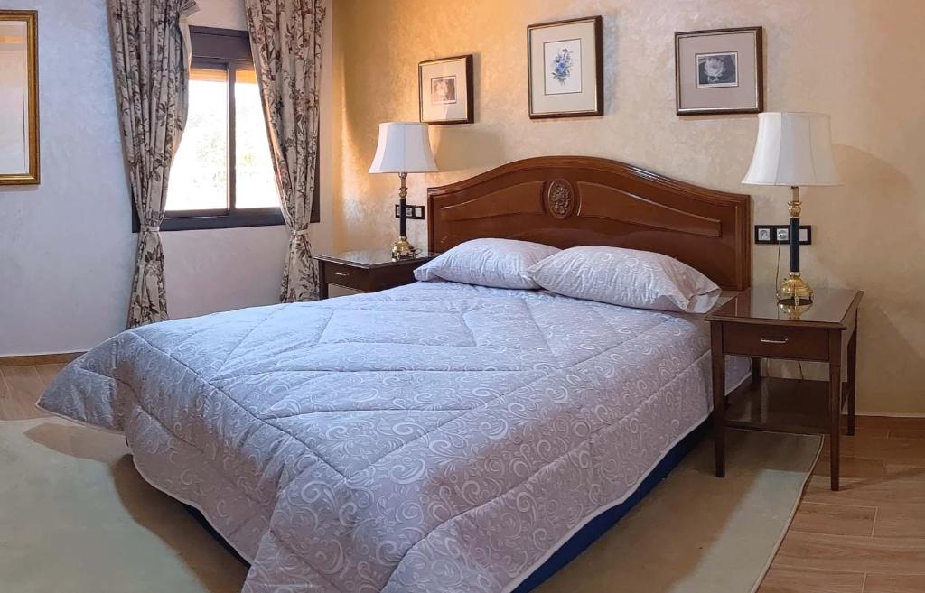 1 dormitorio con 1 cama grande y 2 mesitas de noche en Hôtel La Chambotte, en Imouzzer Kandar